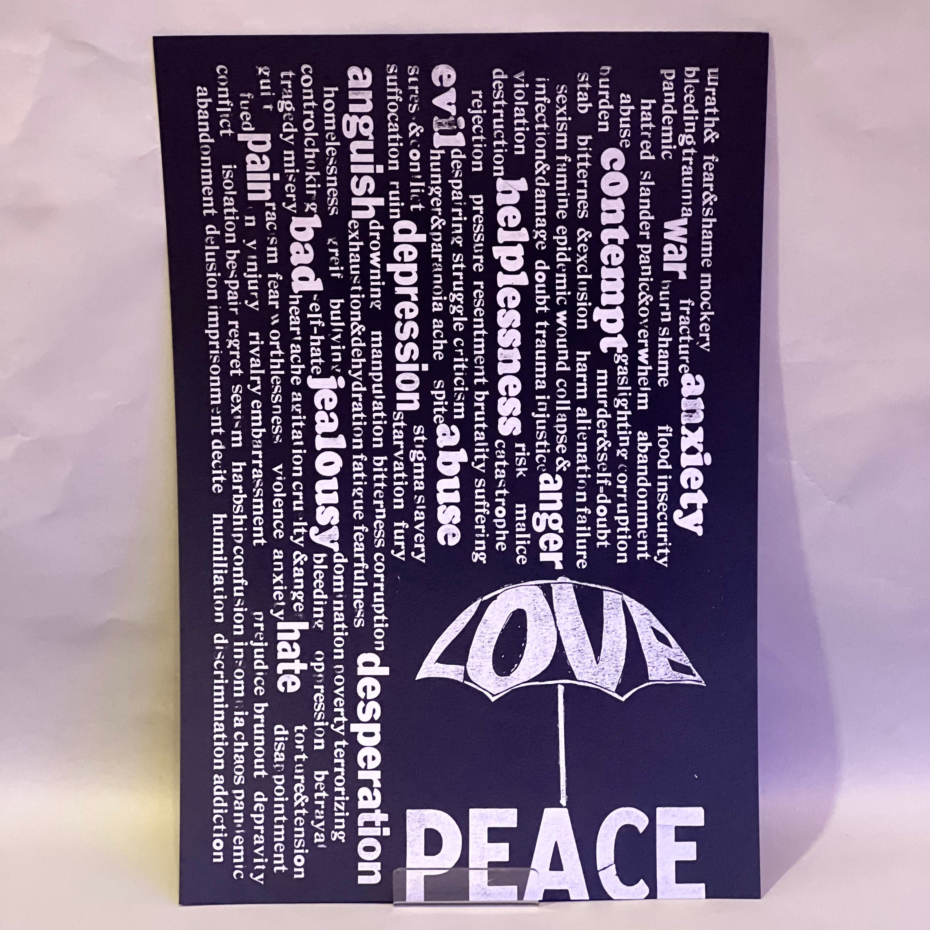 Rain of unpleasant words falling from above, while the word “Love” forms an umbrella that offers protection. Beneath it, the word “Peace”
