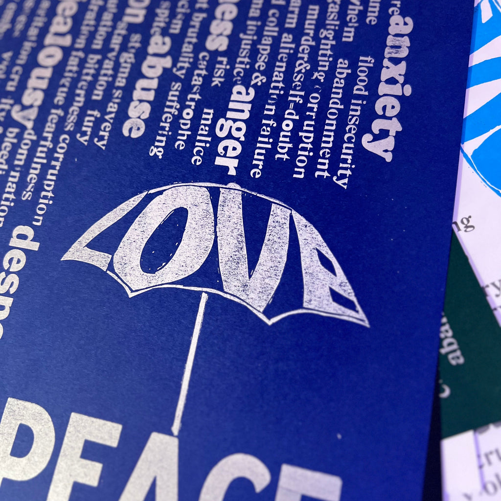 Rain of unpleasant words falling from above, while the word “Love” forms an umbrella that offers protection. Beneath it, the word “Peace”